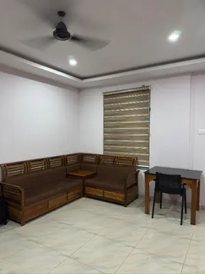 a waiting room with brown benches and a table at RV Tourist Home in Ponnāni