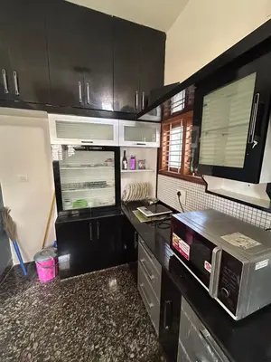 a kitchen with black cabinets and a counter top at Aalaya in Mysore