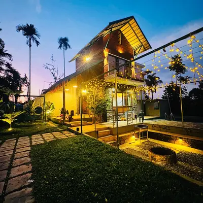 a house with lights on the side of it at Hill Brown Resort in Kalpetta