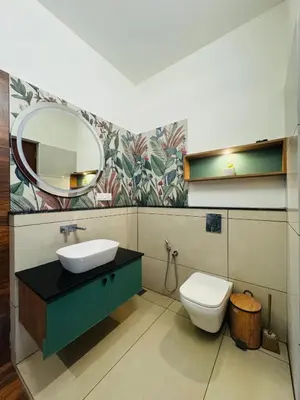 a bathroom with a sink and a toilet and a mirror at Hill Brown Resort in Kalpetta