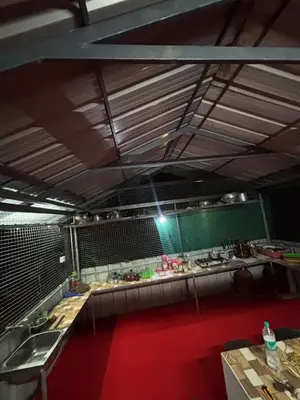a large kitchen with a red floor and a counter top at ViAN Mistyrocks in Mamalakandam