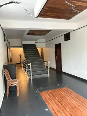 a room with a staircase with a chair and a table at Highland Residency in Attappādi