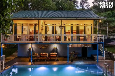 a house with a pool in front of it at StayVista at Aradhya Villa with Infinity Pool, Lawn in Wayanad