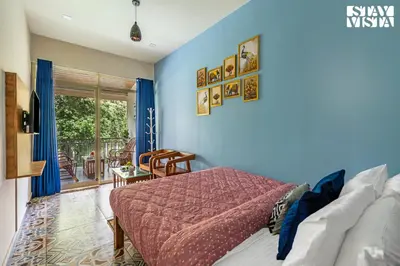 a bedroom with blue walls and a bed and a patio at StayVista at Aradhya Villa with Infinity Pool, Lawn in Wayanad