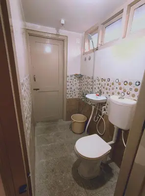 a bathroom with a toilet and a sink at Anava Farms in Shrīrangapattana