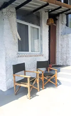two chairs and a wooden table outside of a house at Mad & Nomad Backpackers Hostel in Coonoor