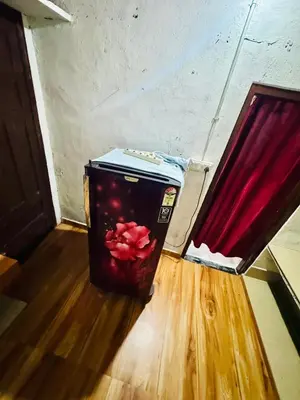 a suitcase sitting on the floor next to a red curtain at rivers edge homestay in Viripara