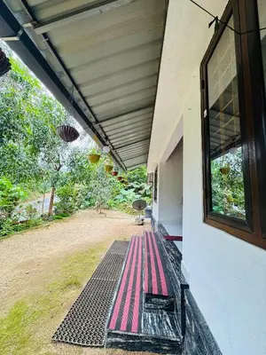 an outside porch of a house with a window at rivers edge homestay in Viripara