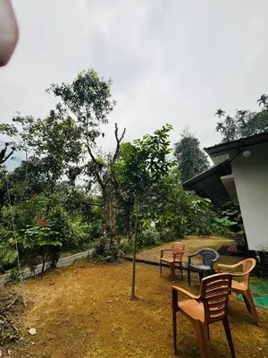 a group of chairs and a table in a yard at rivers edge homestay in Viripara
