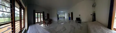 a living room with two beds and a large window at Anishanchala in Madikeri