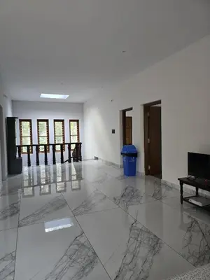 a room with white walls and a marble floor at Anishanchala in Madikeri