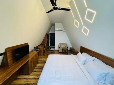 a attic bedroom with a bed and a tv at Mangalath River View Resorts in Kodanad