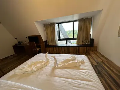 a bedroom with a bed with white sheets and a window at Mangalath River View Resorts in Kodanad