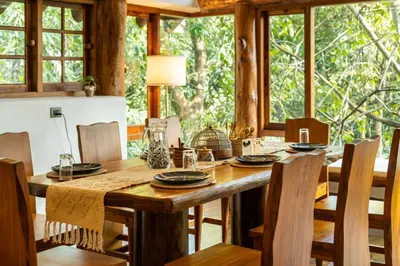 a dining room with a wooden table and chairs at Avana Holiday Experiences,Wayanad in Kalpetta