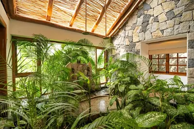 an indoor garden with a waterfall in a building at Avana Holiday Experiences,Wayanad in Kalpetta