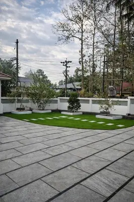 a patio with grass and benches in a yard at Karthika Residency Parakkadavu in Nedumbassery