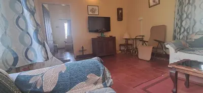 a living room with a couch and a tv at Nadhi Teera Riverside Stay in Kushālnagar