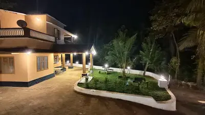 a house with a courtyard at night with lights at Dreamland kizhunna beach homestay in Kannur