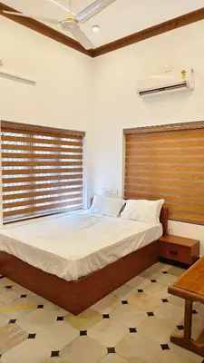 a bedroom with a large bed with a wooden headboard at Dreamland kizhunna beach homestay in Kannur