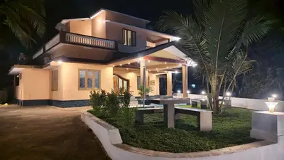 a house with a table in front of it at night at Dreamland kizhunna beach homestay in Kannur