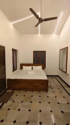 a bedroom with a bed and a ceiling fan at Dreamland kizhunna beach homestay in Kannur