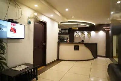 a waiting room with a tv and a counter at Wynad Hotel in Kozhikode