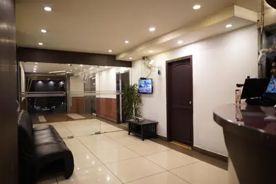 a lobby with a bar and a tv in a building at Wynad Hotel in Kozhikode