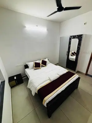 a bedroom with a large bed with a ceiling at Merrat Regency in Trichūr
