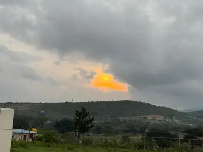 a orange cloud in the sky over a field at Tusker & Gaur - Bandipur