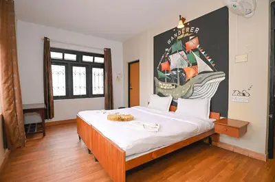 a bedroom with a bed with a poster of a ship at Hotel Vivek in Coonoor