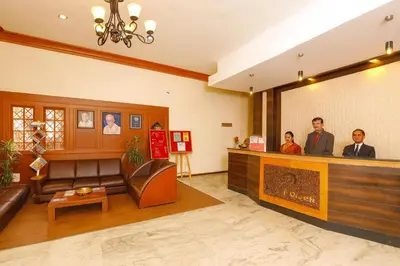 a waiting room with people standing at the counter at Hotel Vivek in Coonoor