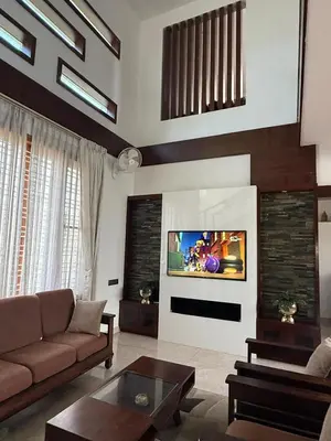 a living room with a couch and a tv at Shan Home Stay in Mysore