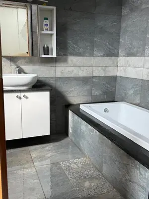 a bathroom with a bath tub and a sink at Shan Home Stay in Mysore