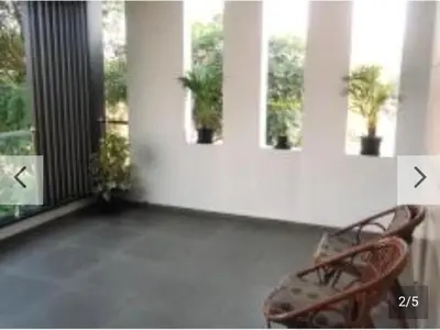 a room with two chairs and two windows at Shan Home Stay in Mysore
