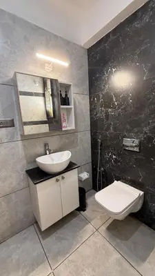 a bathroom with a sink and a toilet at Shan Home Stay in Mysore