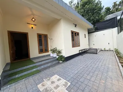 a house with a patio and a driveway at Ethnic Family Spot Wayanad in Kenichira