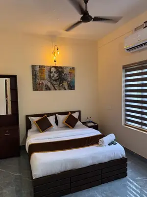 a bedroom with a large bed with a ceiling fan at Ethnic Family Spot Wayanad in Kenichira