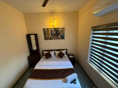 a bedroom with two beds and a window at Ethnic Family Spot Wayanad in Kenichira