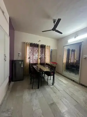 a dining room with a table and a ceiling fan at Rose villa in Coimbatore