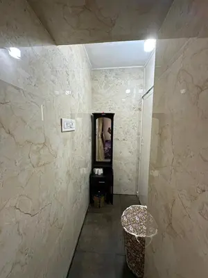 a hallway with a mirror and a stool in a room at Rose villa in Coimbatore
