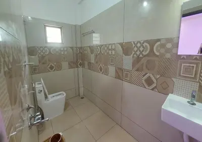 a bathroom with a toilet and a sink at Carmel Cottage in Marayoor