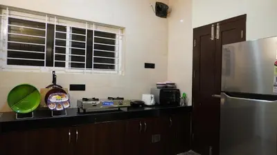 a kitchen with a counter with a refrigerator and a clock at Luxurious Private Vantage Villa - Kotagiri in Kotagiri