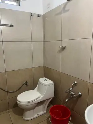 a bathroom with a toilet and a sink at Sparsha rooms in Kaniyāmbetta