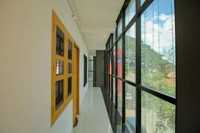 a hallway with large windows in a building at Sparsha rooms in Kaniyāmbetta