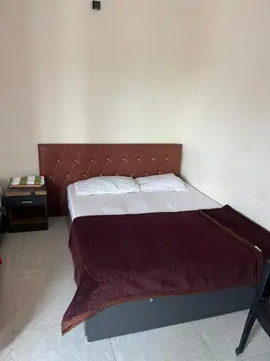 a large bed with a brown headboard in a room at Sparsha rooms in Kaniyāmbetta