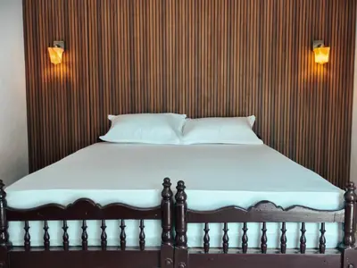 a bed in a room with a wooden wall at Bamboo villa in Cochin