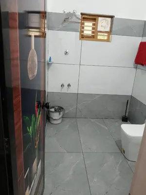 a bathroom with a toilet and a clock on the wall at River View Resort, Nilambur in Nilambūr