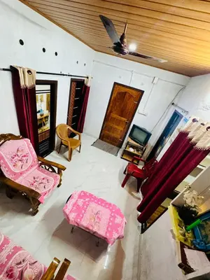 a living room with pink furniture and a ceiling at Parathanathu Homestay in Viripara