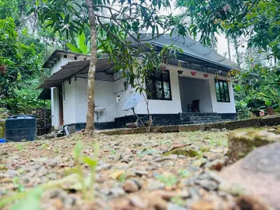 a small white house with a tree in front of it at Parathanathu Homestay in Viripara