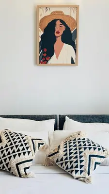 a painting of a woman with a hat on a bed at BOHO Living Kochi Airport in Ernakulam